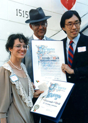 Councilman Michael Woo presents Owner Mort La Kretz and his daughter Margaret with the City of Los Angeles' recognition of Crossroads' 50th anniversary